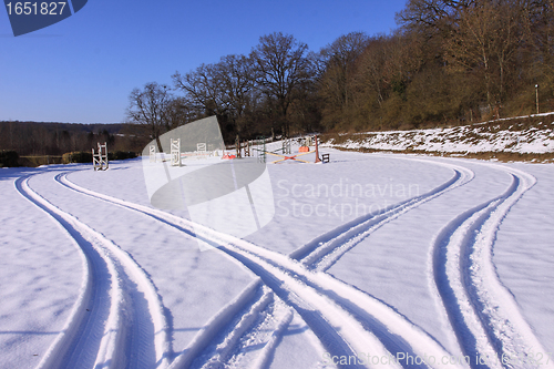 Image of tire tracks in the snow in winter