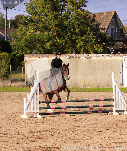 Image of pretty young woman rider in a competition riding