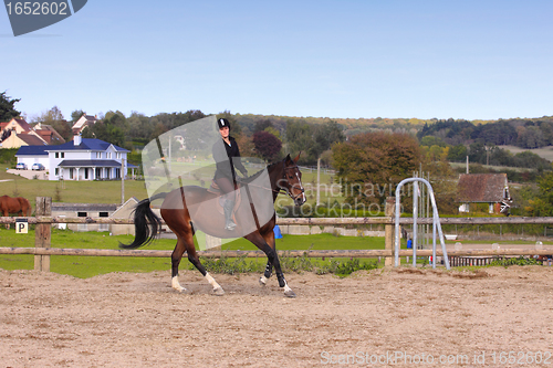 Image of pretty young woman rider in a competition riding