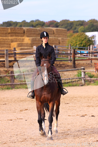 Image of pretty young woman rider in a competition riding