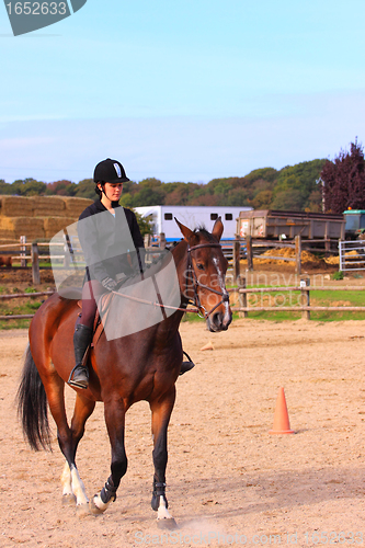 Image of pretty young woman rider in a competition riding