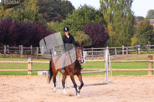 Image of pretty young woman rider in a competition riding