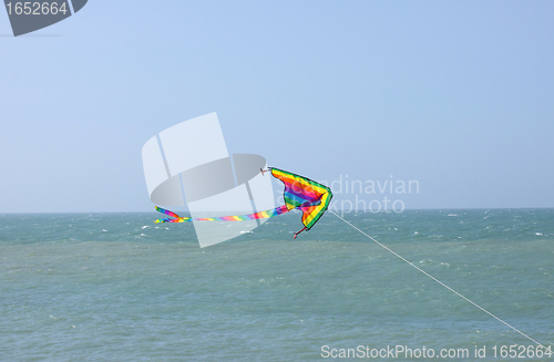 Image of kite in a blue sky above the sea