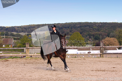 Image of pretty young woman rider in a competition riding