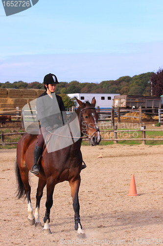 Image of pretty young woman rider in a competition riding