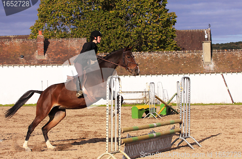 Image of pretty young woman rider in a competition riding