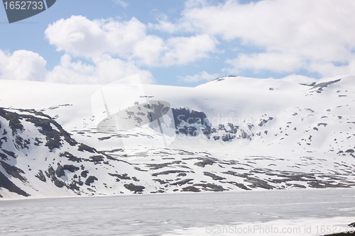 Image of frozen lake and snowy mountains in norway