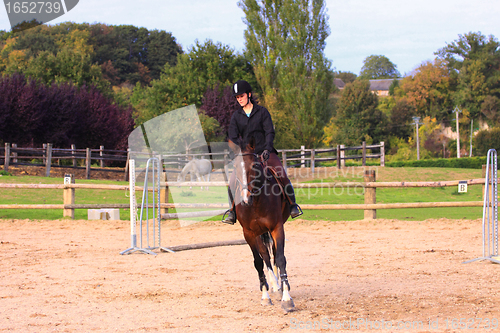 Image of pretty young woman rider in a competition riding