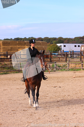 Image of pretty young woman rider in a competition riding