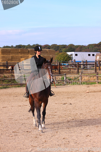 Image of pretty young woman rider in a competition riding