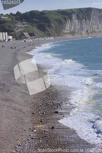 Image of wave and foam on a pebble beach in Etretat