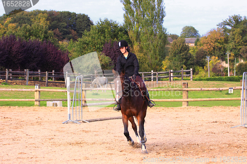 Image of pretty young woman rider in a competition riding