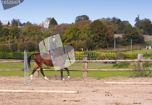 Image of pretty young woman rider in a competition riding