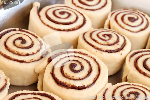 Image of Raw cinnamon buns ready to bake with selective focus.