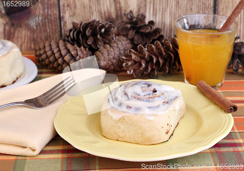 Image of Delicious Cinnamon Bun with a glass of apple cider.