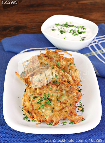 Image of Potato Latkes and sour cream, vertical.