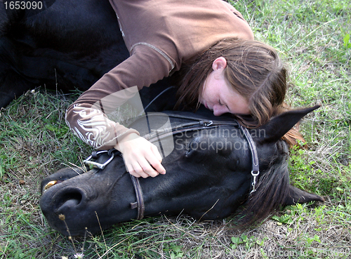 Image of horse laid down and riding girl