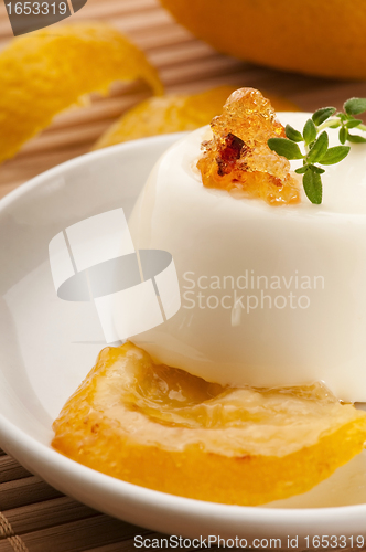 Image of Vanilla Panna Cotta Dessert with lemon and fresh herbs