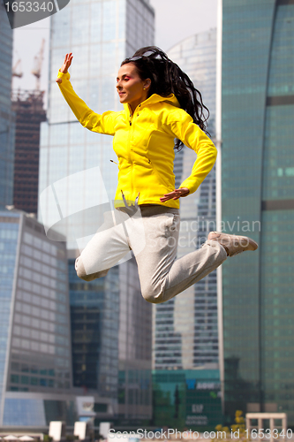 Image of brunette in a yellow blazer jumping