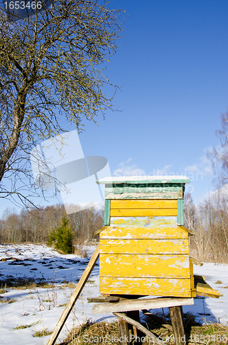 Image of Bee hive home in spring garden melt snow and sky 