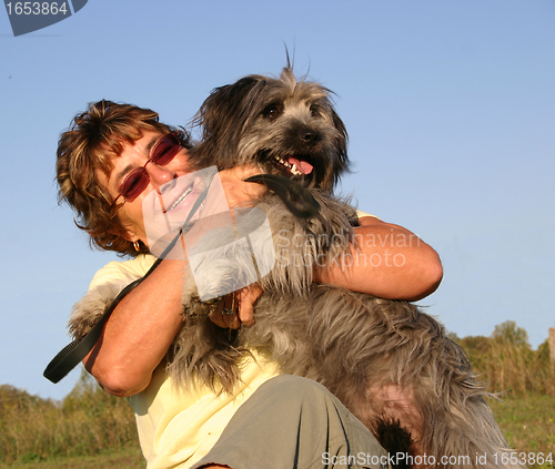 Image of Pyrenean sheepdog and senior woman