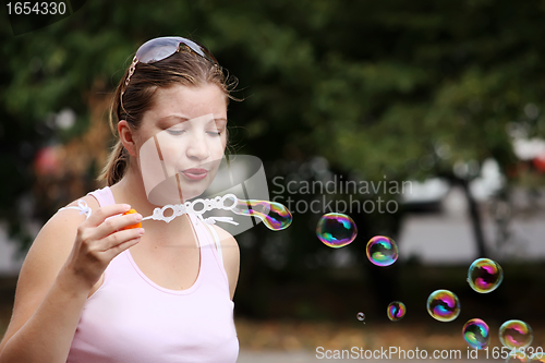 Image of Yung woman blows bubbles