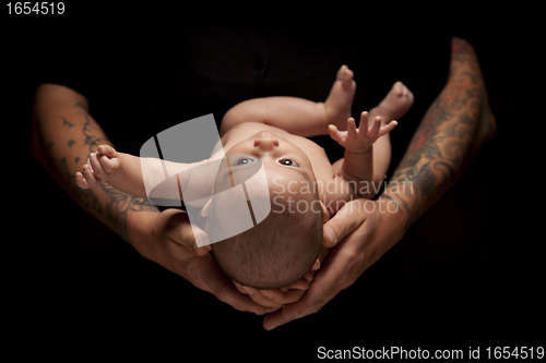 Image of Hands of Father and Mother Hold Newborn Baby on Black