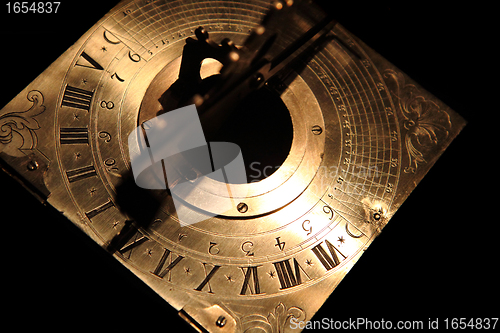 Image of very old golden sundial beneath