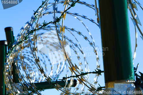 Image of barbed wire against blue sky 
