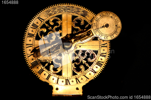 Image of veyr old golden sundial beneath