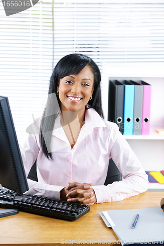 Image of Smiling black businesswoman at desk