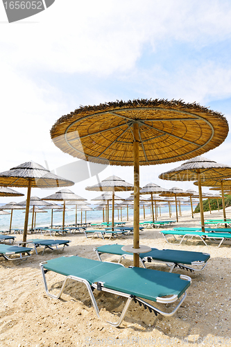 Image of Beach umbrellas and chairs on sandy seashore