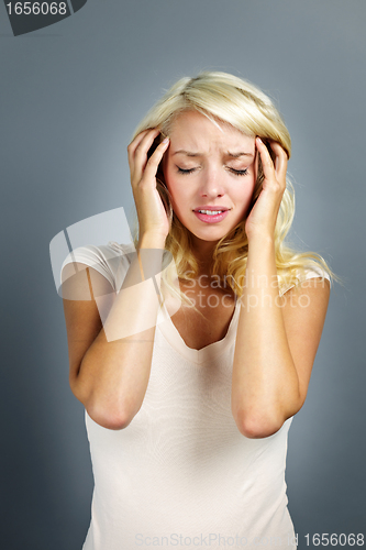 Image of Unhappy woman holding her head