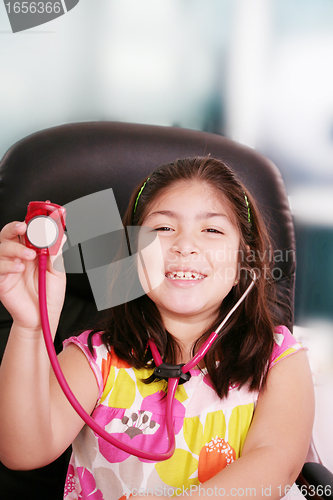Image of Cute little girl is playing doctor with stethoscope, isolated ov