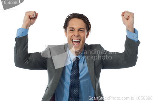 Image of Excited businessman rasing his arms and cheering joyfully