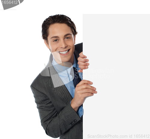 Image of Businessman peeping from behind the blank board