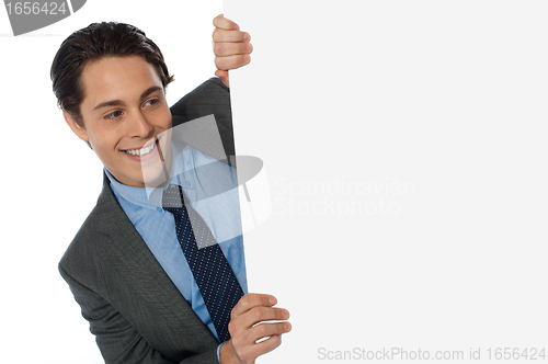 Image of Businessman looking around the corner