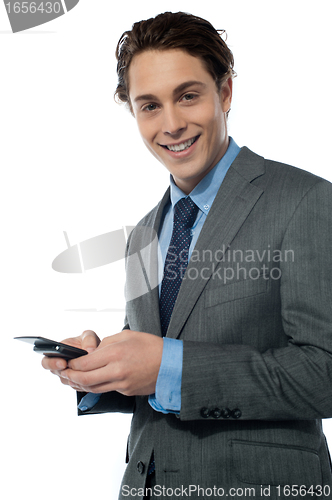 Image of Handsome young man navigating on his smartphone