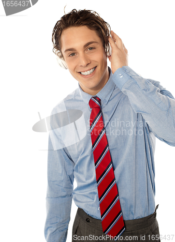 Image of Relaxed young smiling male listening to music