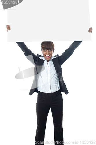 Image of Excited businesswoman poisng with billboard