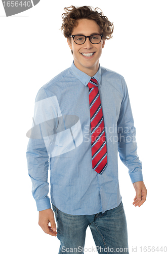 Image of A young teenager in blue shirt, jeans and tie