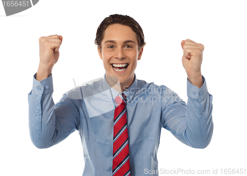 Image of Businessman celebrating success with arms raised