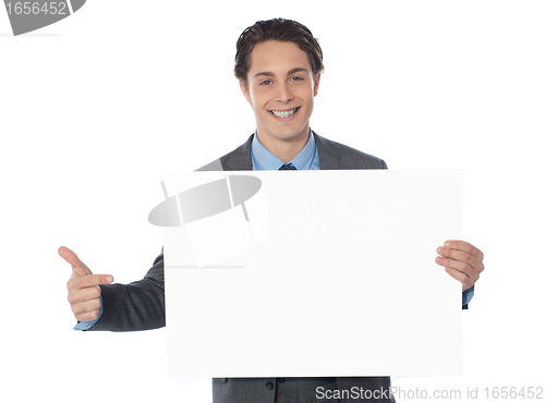 Image of Male executive pointing towards blank billboard