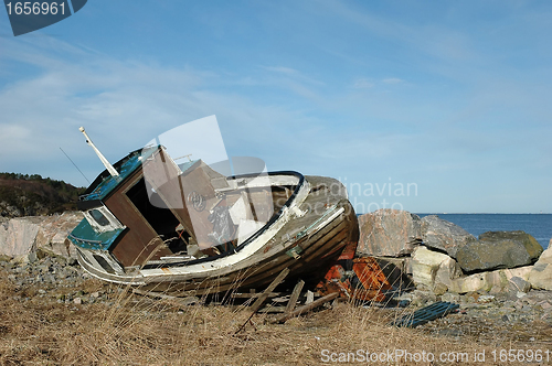 Image of old wooden boats on rocky seaside