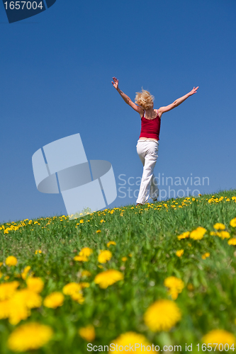Image of young woman in red outfit having fun on meadow