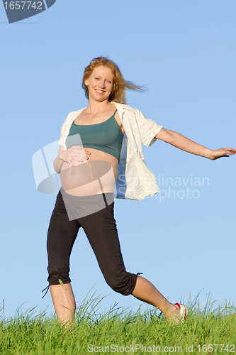 Image of pregnant woman on meadow