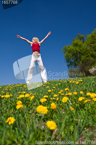 Image of young woman in red outfit having fun on meadow