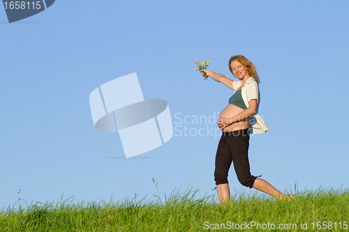 Image of pregnant woman on meadow