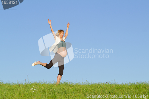 Image of pregnant woman on meadow