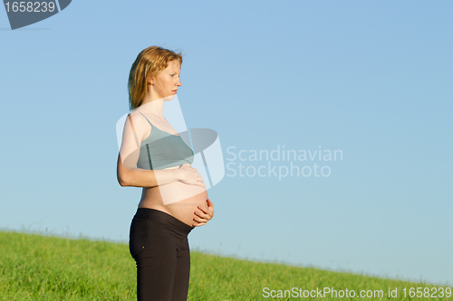 Image of pregnant woman on meadow